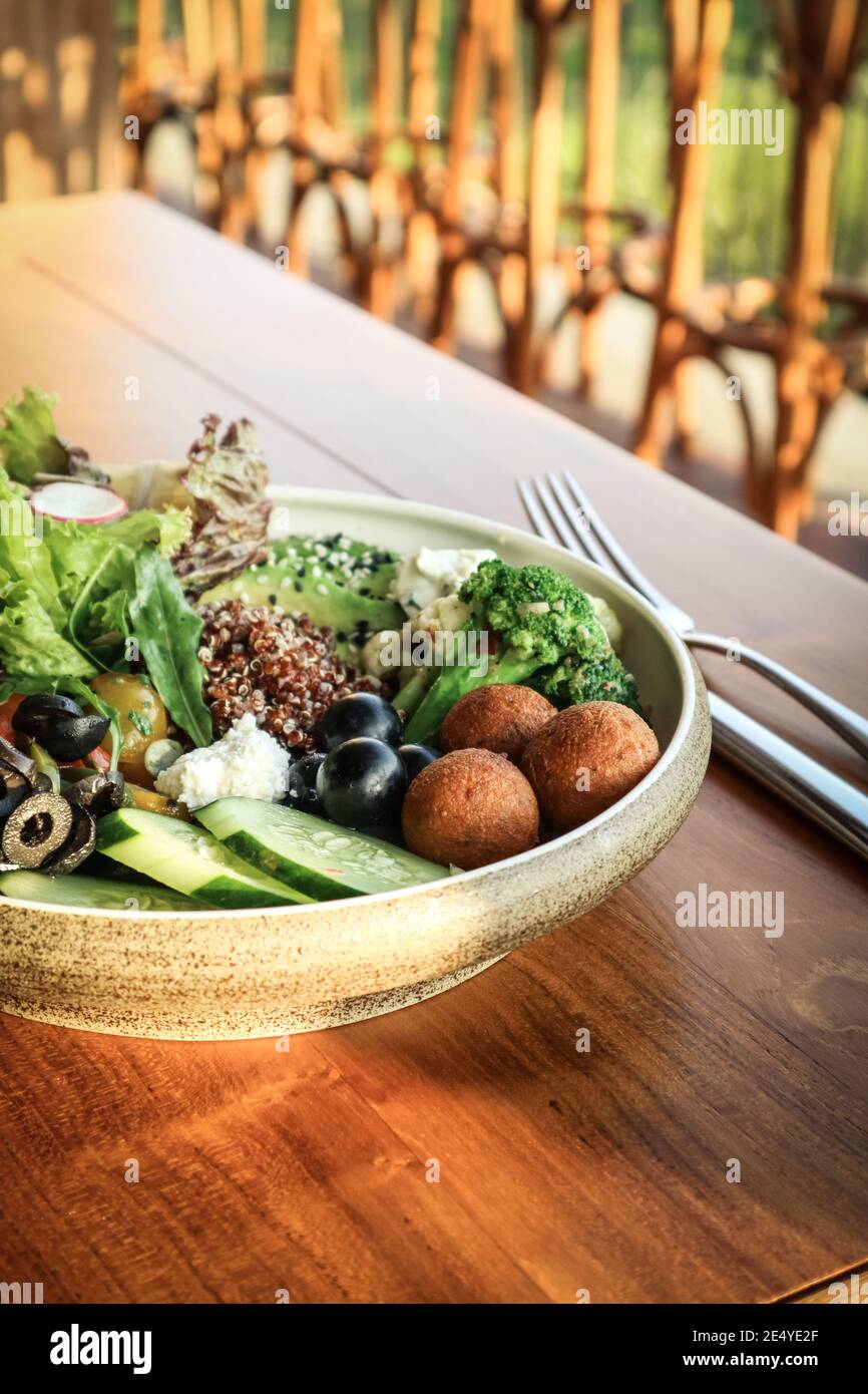 Homemade spiced tempeh falafel and quinoa bowl in plate on table closeup. Stock Photo