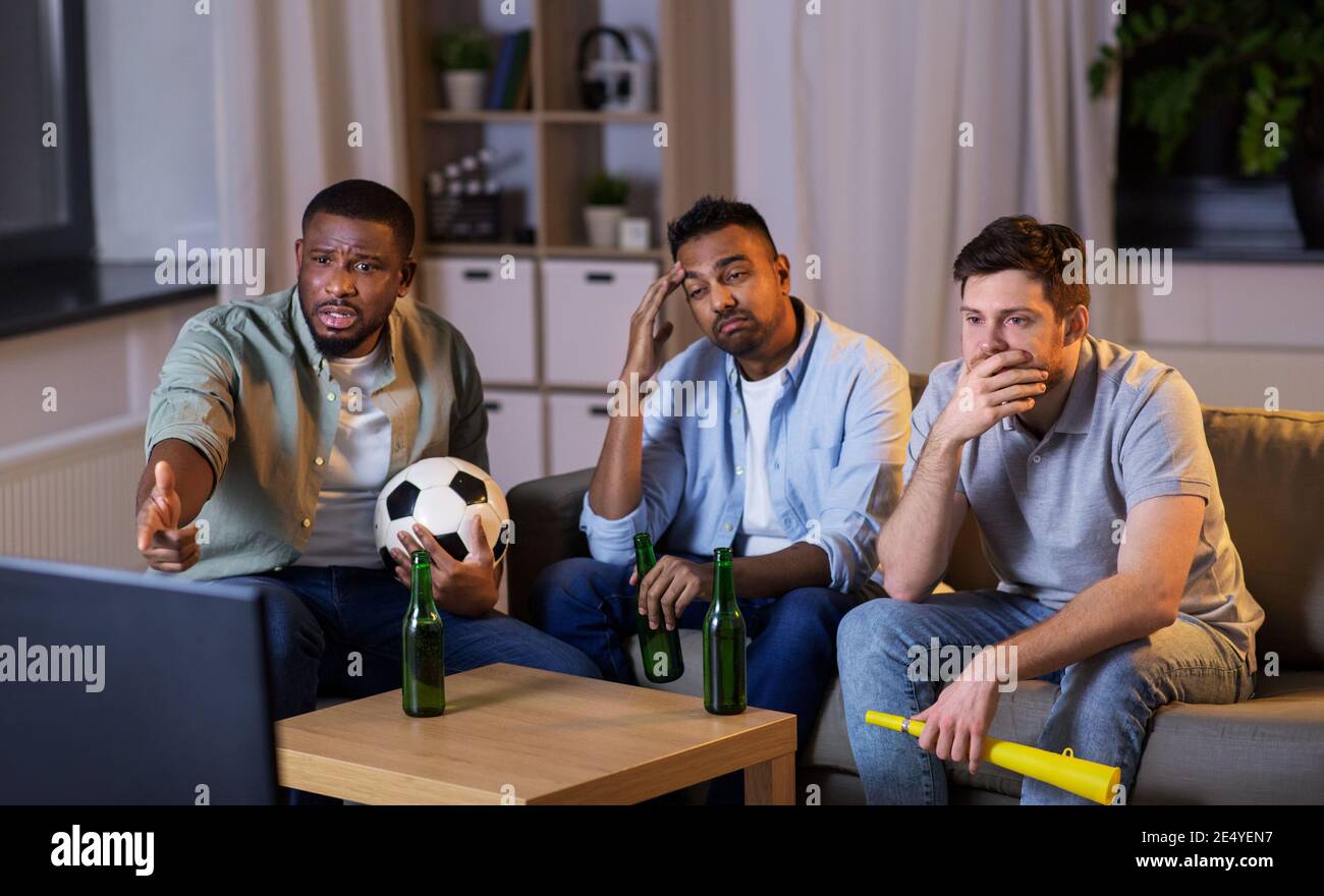 friends with ball and vuvuzela watching soccer Stock Photo