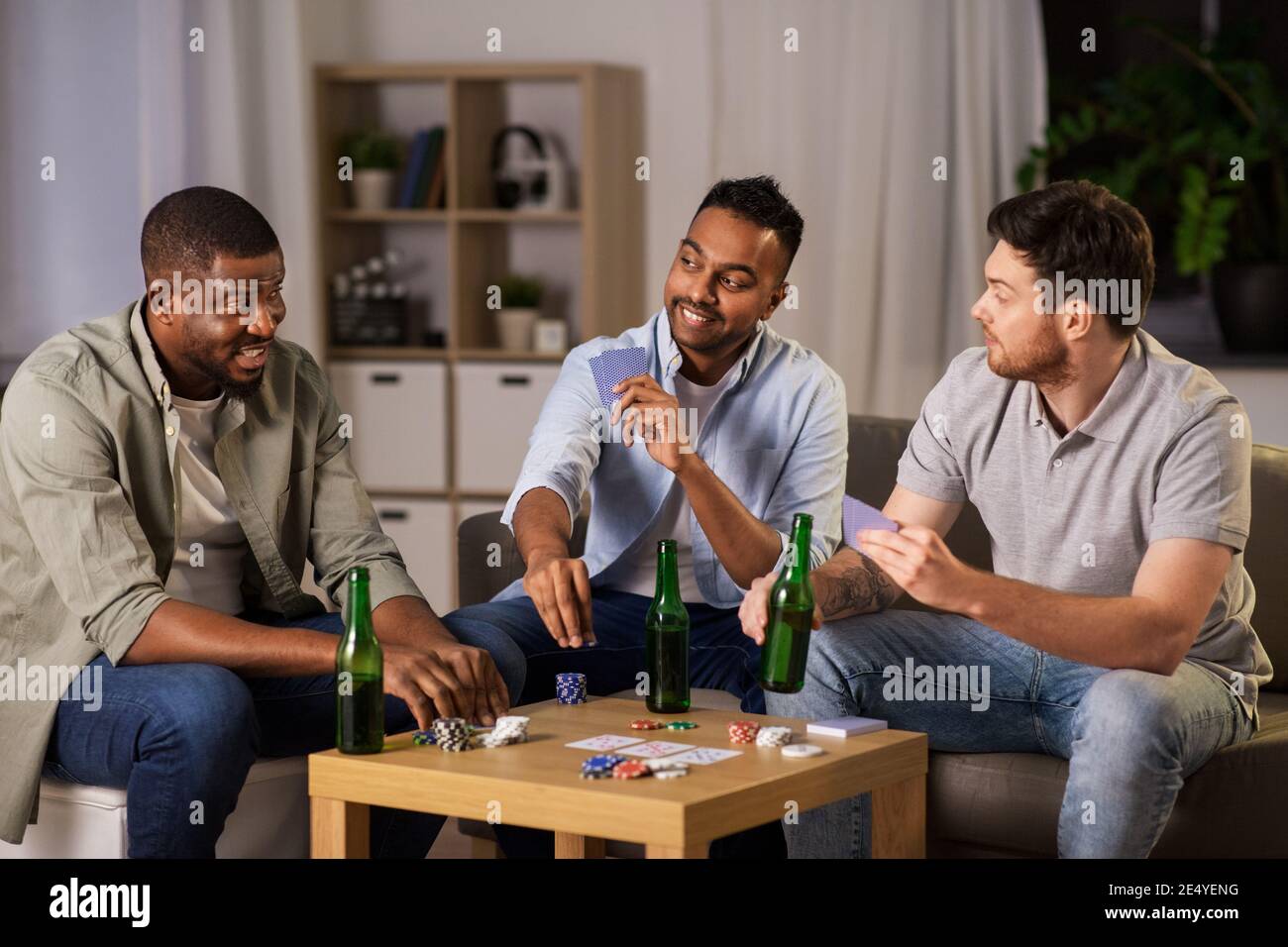 happy male friends playing cards at home at night Stock Photo - Alamy