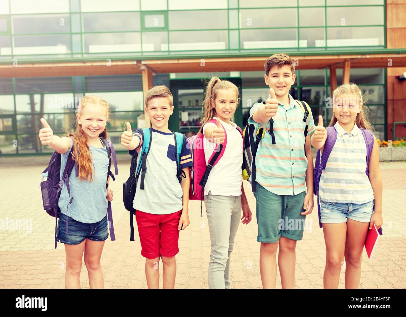 happy elementary school students showing thumbs up Stock Photo - Alamy