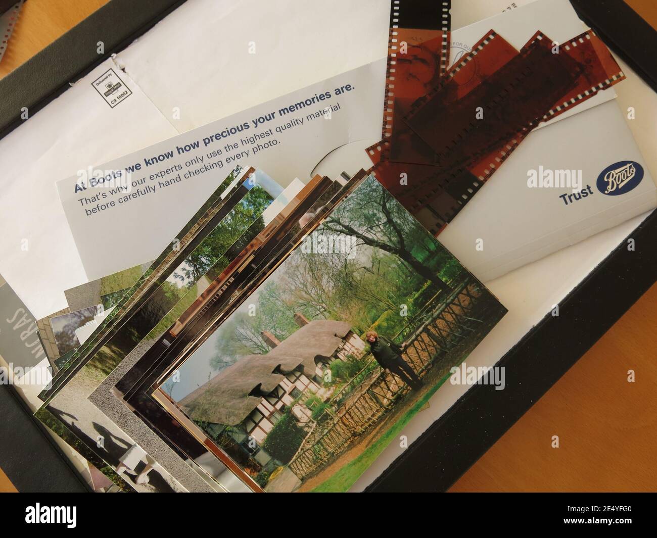 Strip of negatives, a stack of printed photographs and the wallet from