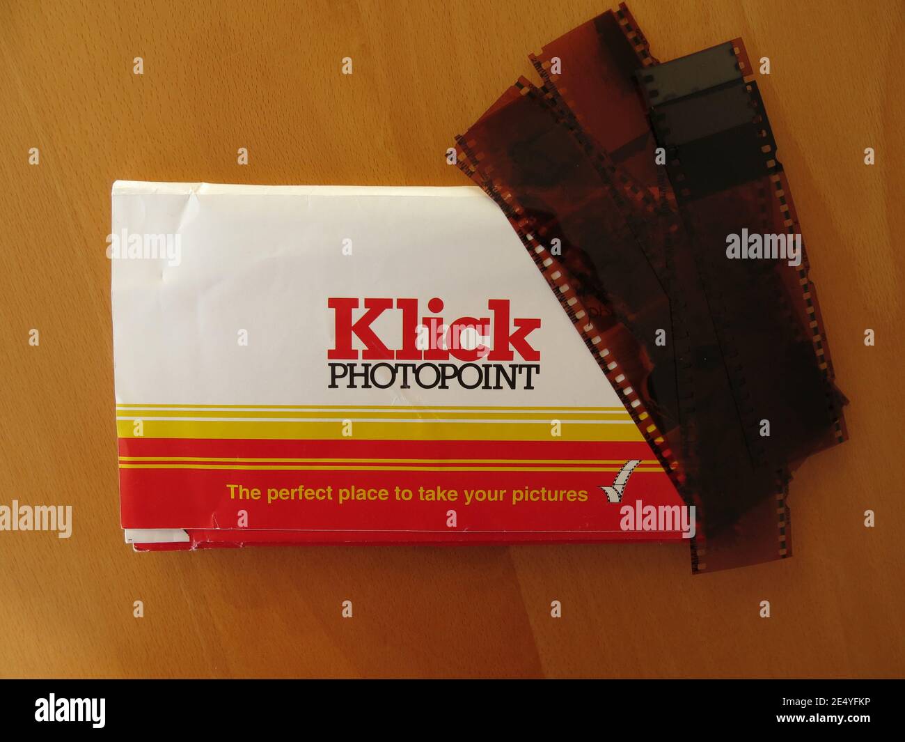 A strip of negatives and the wallet provided for your prints from the photo developing company Klick Photopoint. Stock Photo