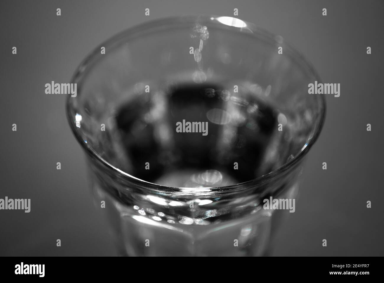 Top of a drinking glass filled with fresh water against a dark