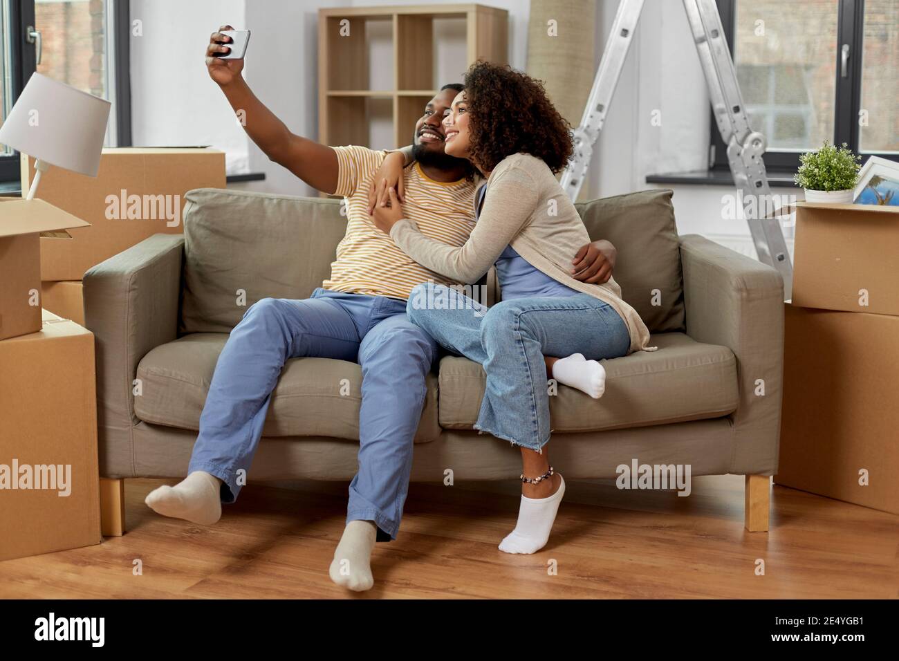 happy couple moving to new home and taking selfie Stock Photo - Alamy
