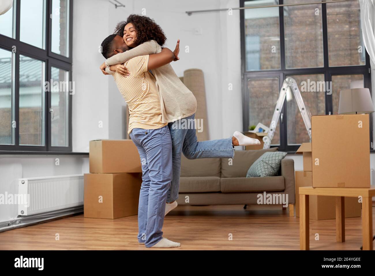 happy couple with boxes moving to new home Stock Photo - Alamy