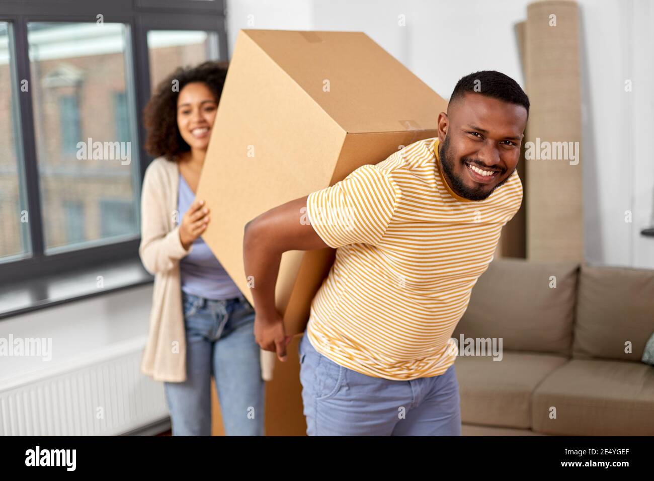 happy couple with boxes moving to new home Stock Photo - Alamy