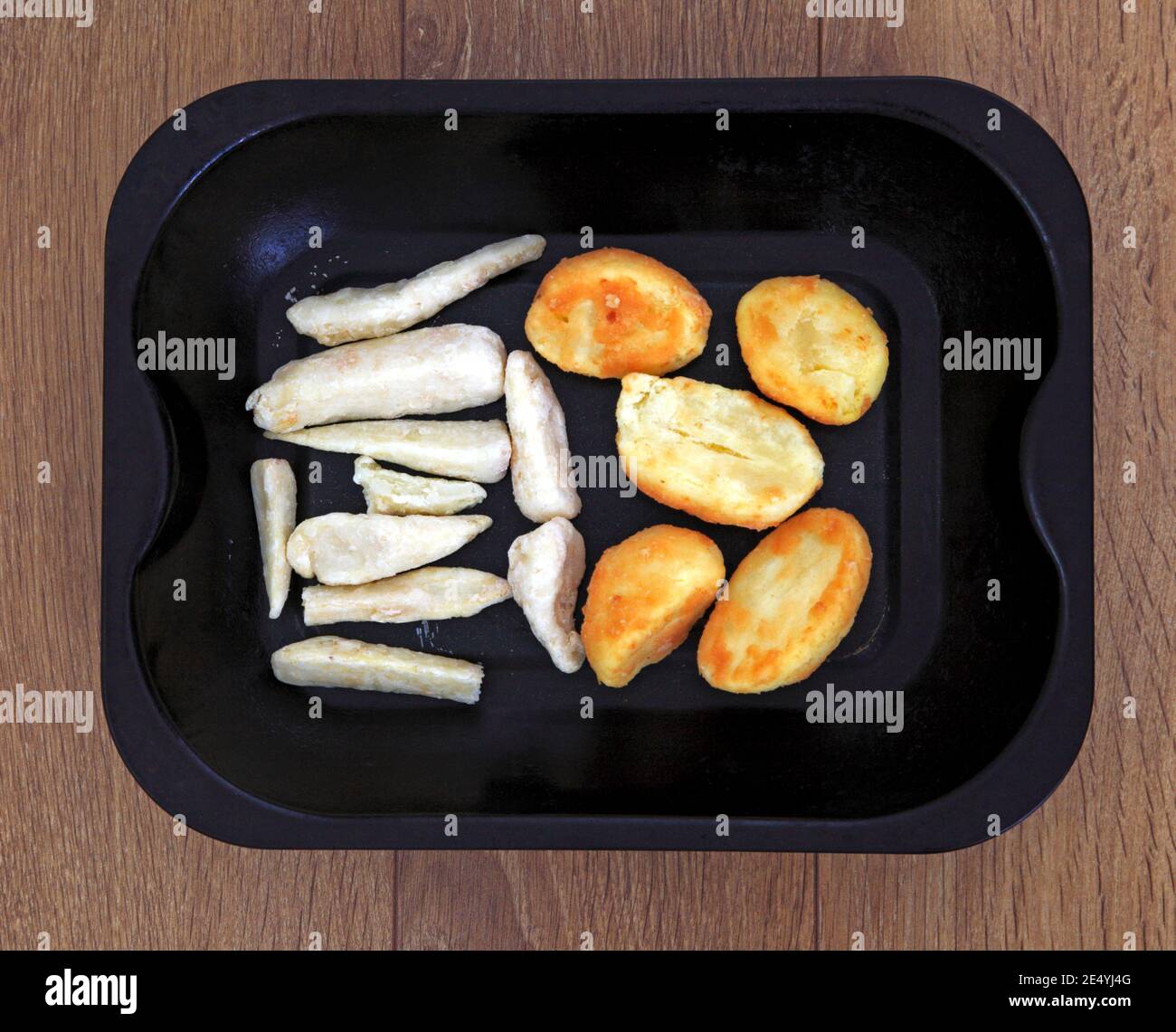 Frozen parsnips and frozen roast potatoes in a roasting tin ready for