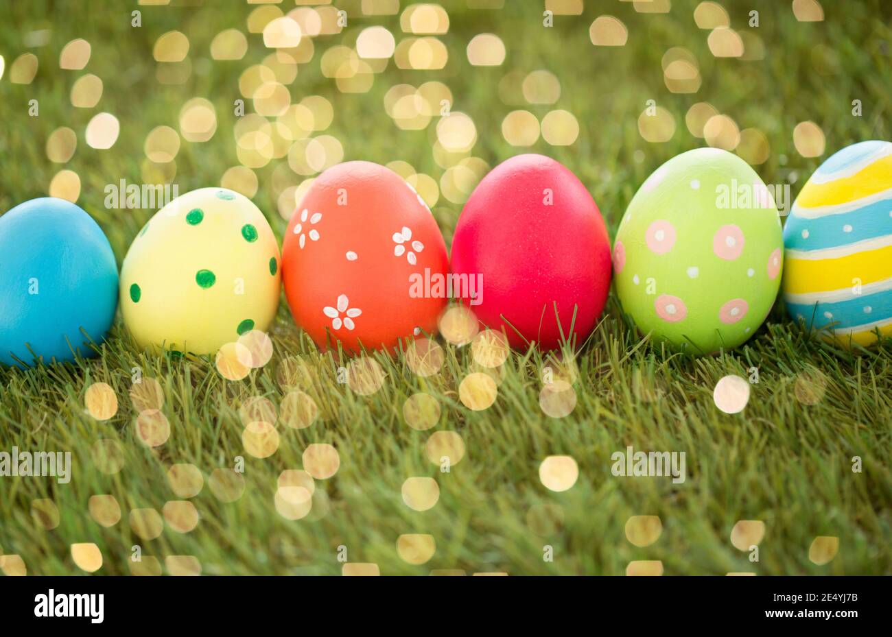 row of colored easter eggs on artificial grass Stock Photo