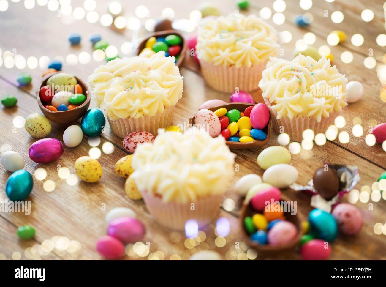 cupcakes with easter eggs and candies on table Stock Photo