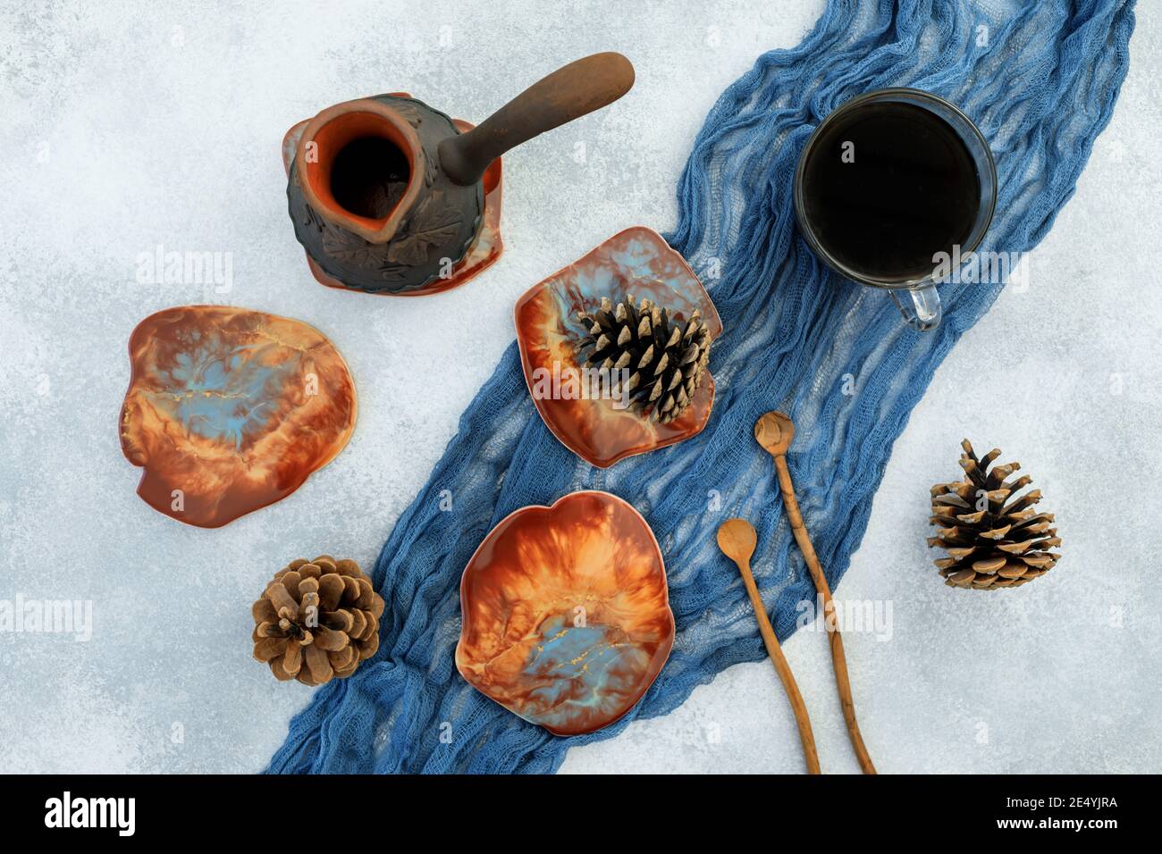 Composition with coffee cup and resin art plates on blue textile background. Flat lay, top view Stock Photo