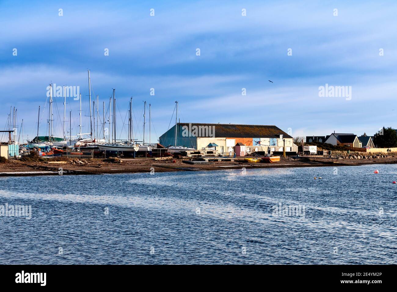 FINDHORN VILLAGE MORAY COAST SCOTLAND THE CAFE BUILDING AND STORED YACHTS OVERLOOKING THE BAY Stock Photo