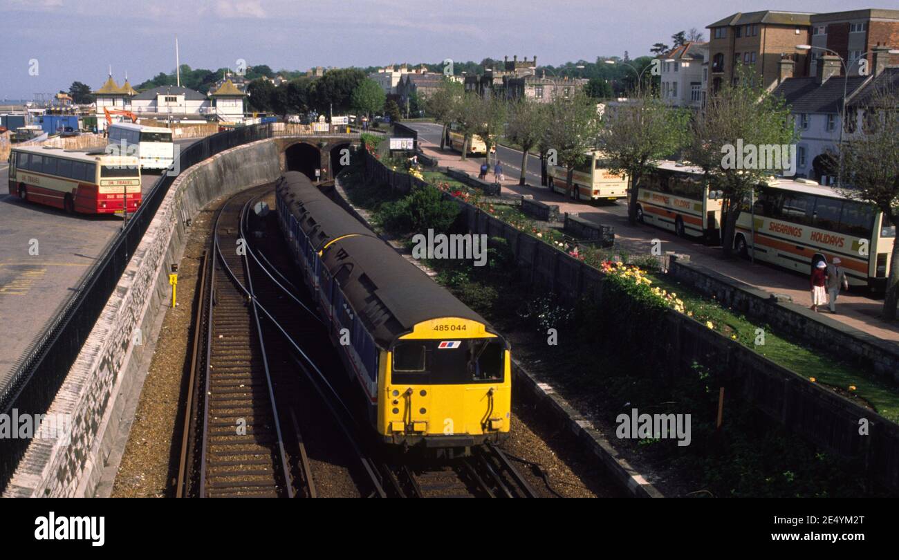 Class 486 ln Network South East livery leaving the tunnel at Ryde Esplanade station on Isle of Wight with tourist coaches parked in the background Stock Photo