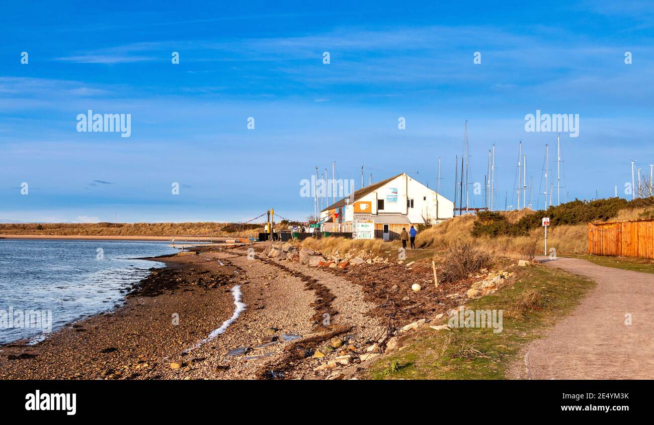 FINDHORN VILLAGE MORAY COAST SCOTLAND THE CAFE BUILDING OVERLOOKING THE BAY  ICE AND SNOW ON THE PEBBLE BEACH Stock Photo