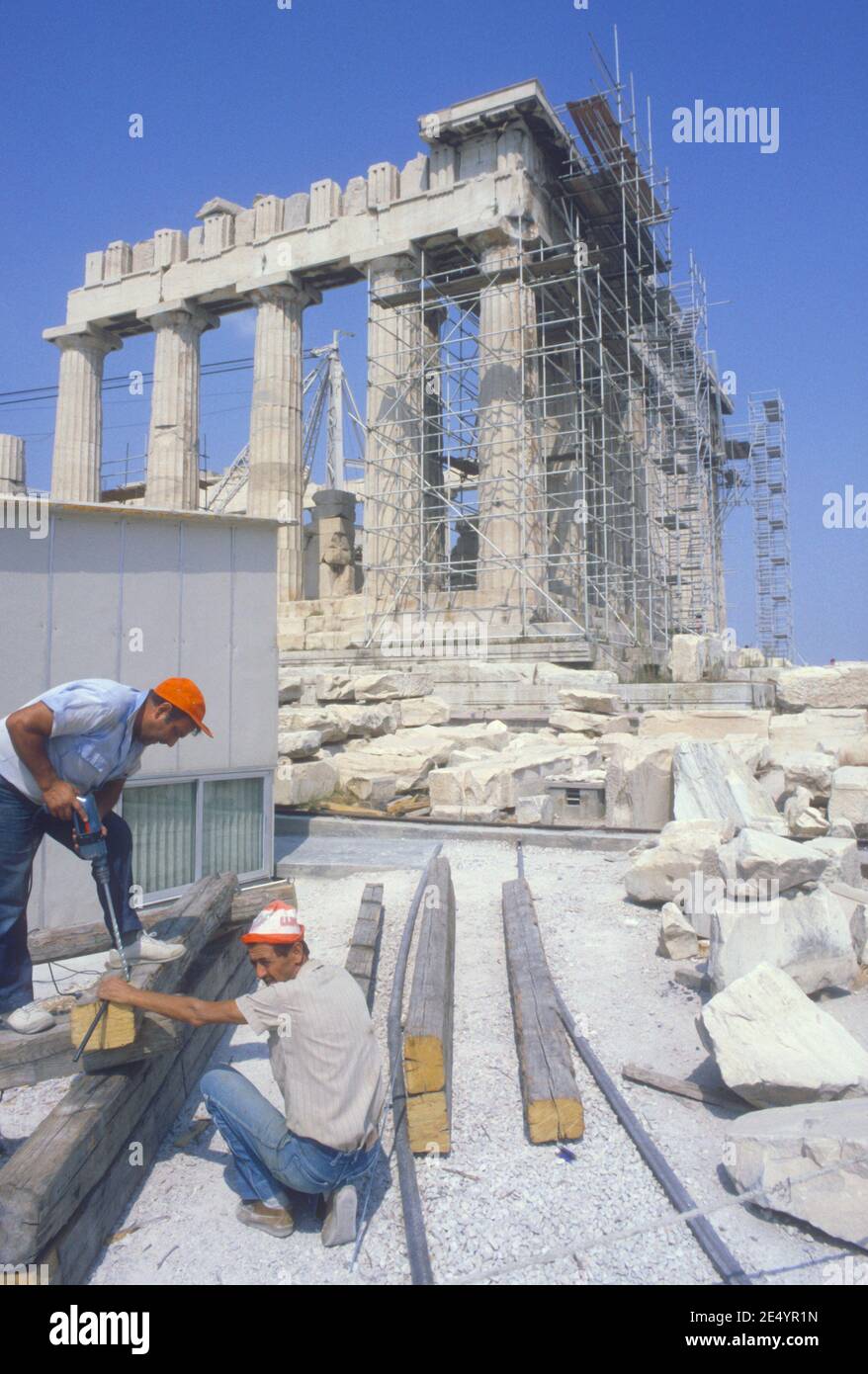 1986 Athens Parthenon and Acropolis Athens Greece.The Parthenon is a former  temple on the Athenian Acropolis, Greece, dedicated to the goddess Athena.  The Parthenon temple is here undergoing restoration with two men