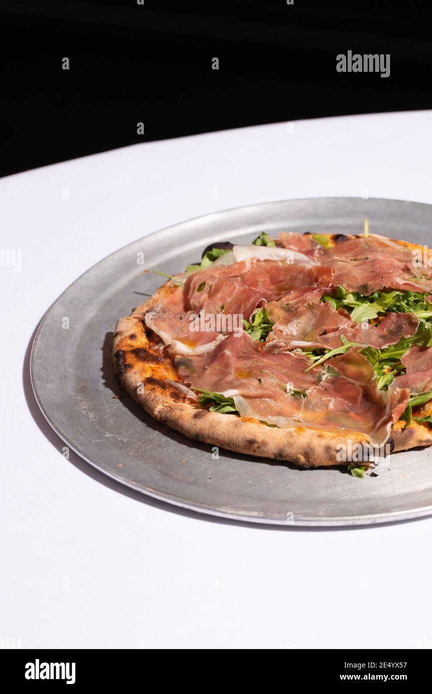 Brick Oven Pizza with Prosciutto and Arugula Stock Photo