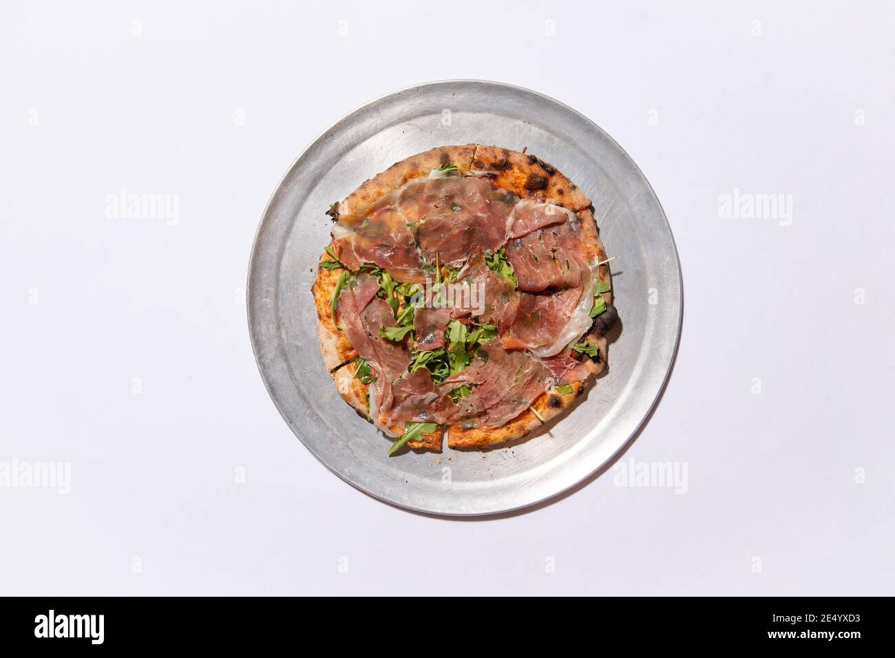 High Angle View of Brick Oven Pizza with Prosciutto and Arugula Stock Photo