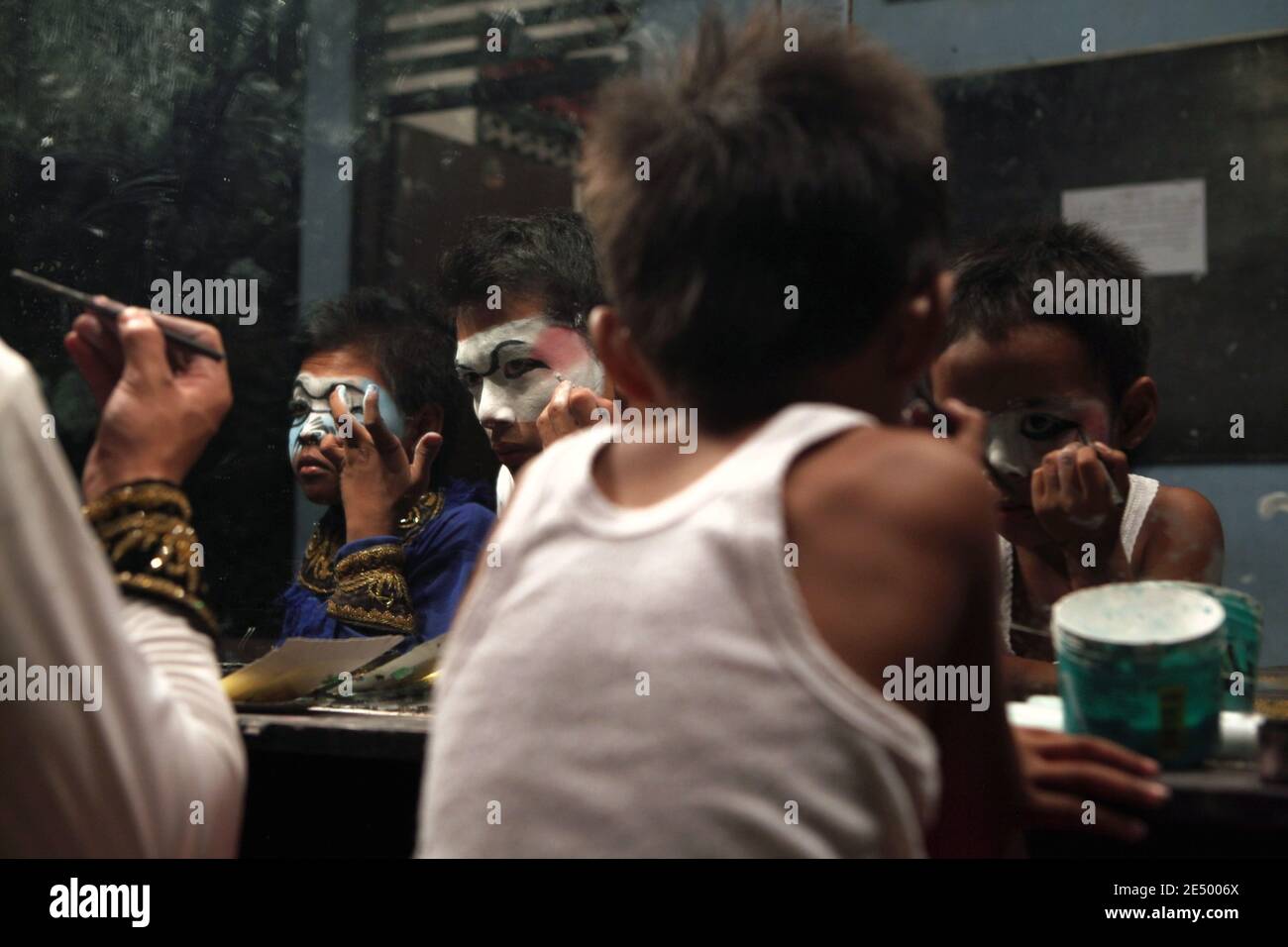 Young performers make themselves up as the Monkeys for the wayang orang performance based on the Ramayana in the Purawisata Theatre in Yogyakarta, Central Java, Indonesia. The performer dressed as Hanuman the Monkey King is pictured at the middle. Wayang orang or Wayang wong (literally 'human theatre') is a traditional Javanese dance and drama theatrical performance based on the Indian epic Ramayana or Mahabharata. The Purawisata Theatre performs the Ramayana Ballet adopted for the foreign tourists every day. Stock Photo