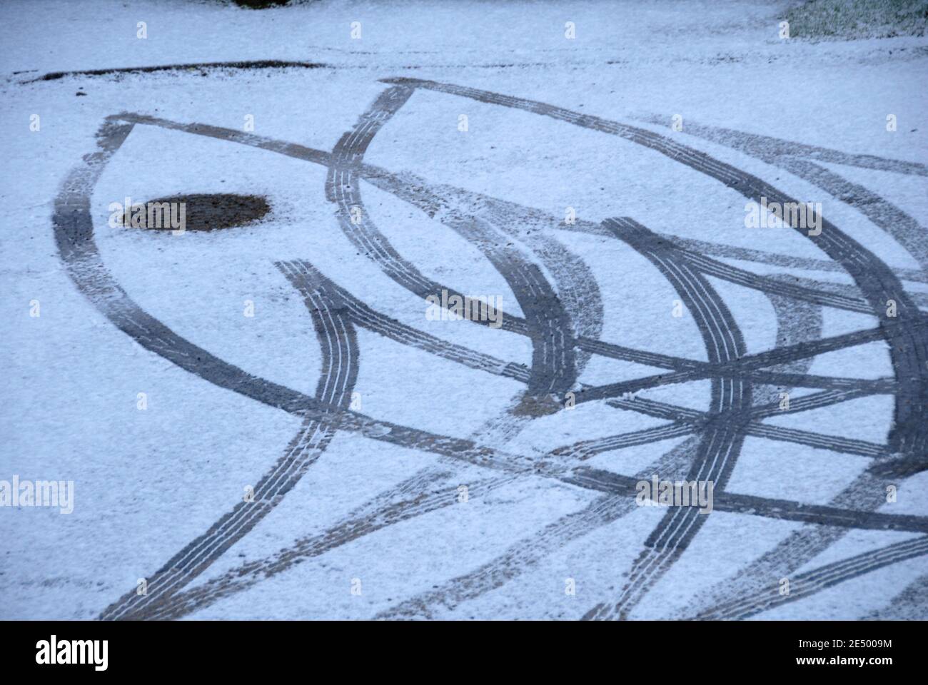 Abstract of tracks in light snow where vehicle has turned and reversed and left marks as evidence Stock Photo