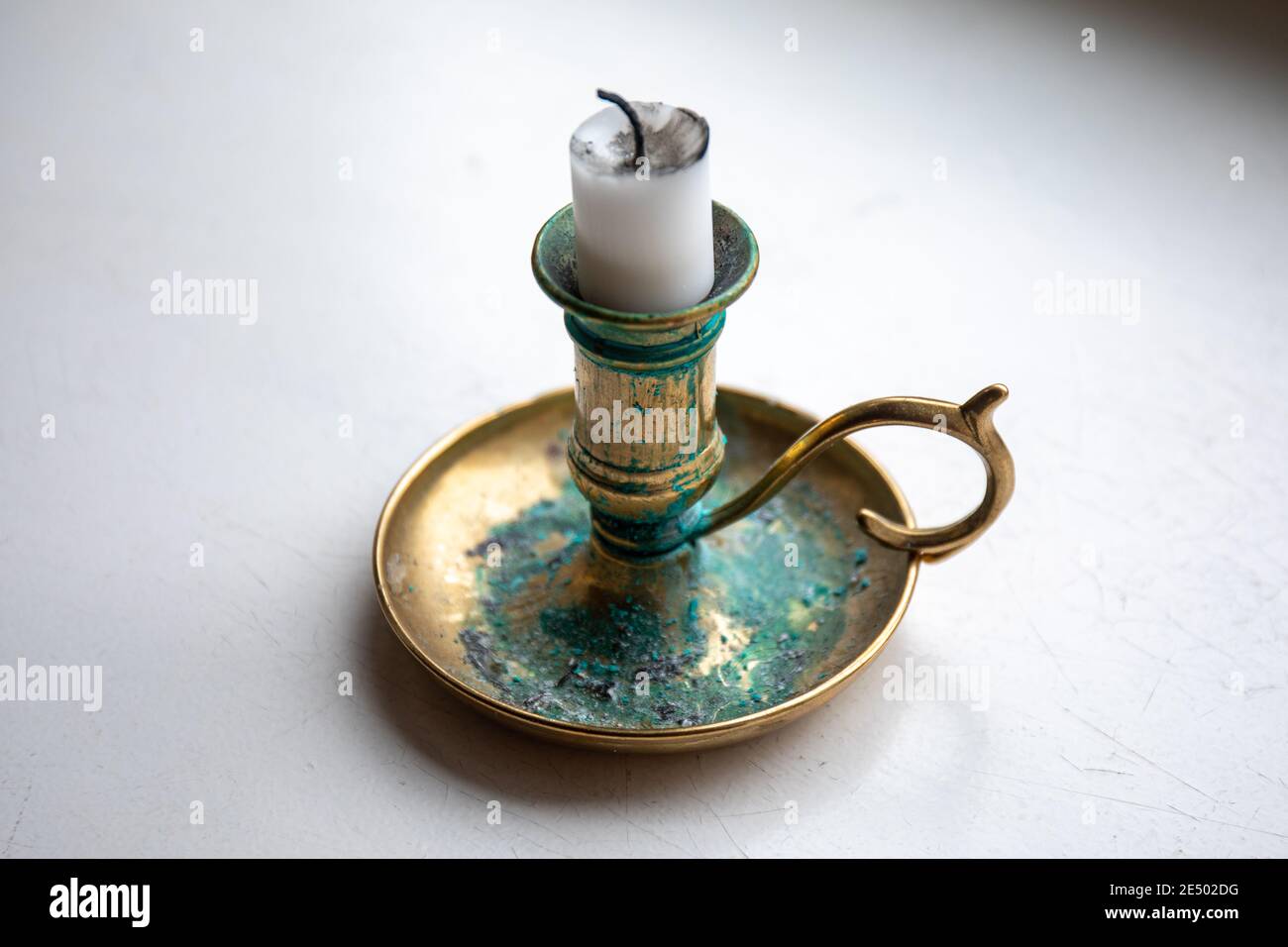 Candle stub on a brass candleholder or candlestick with patina or verdigris Stock Photo