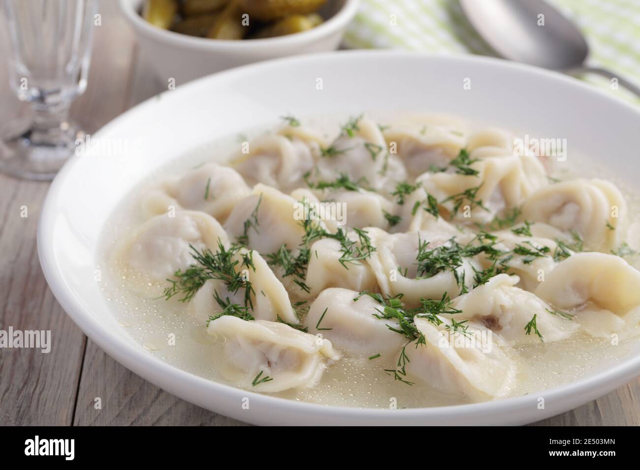 Pelmeni the traditional Russian dumplings served with broth and dill Stock Photo