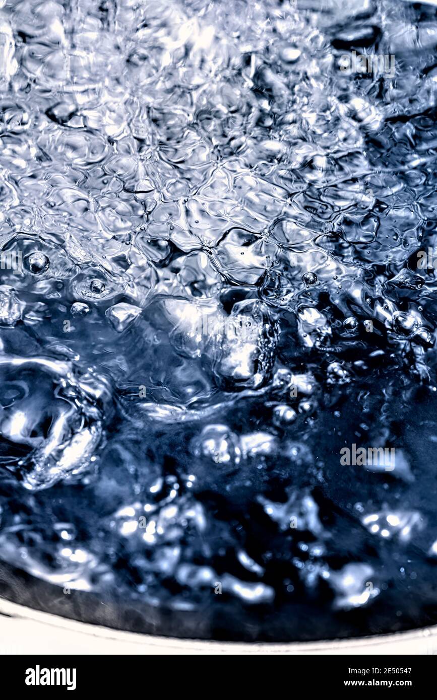 Extreme vertical close-up of water boiling in a pot. Stock Photo