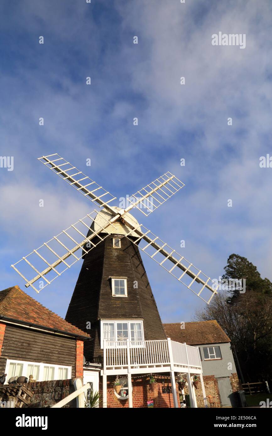 Charing Windmill, Charing, Kent, England. Early 19th century smock mill faced with weatherboarding. Octagonal red brick 'round-house' with wooden plat Stock Photo