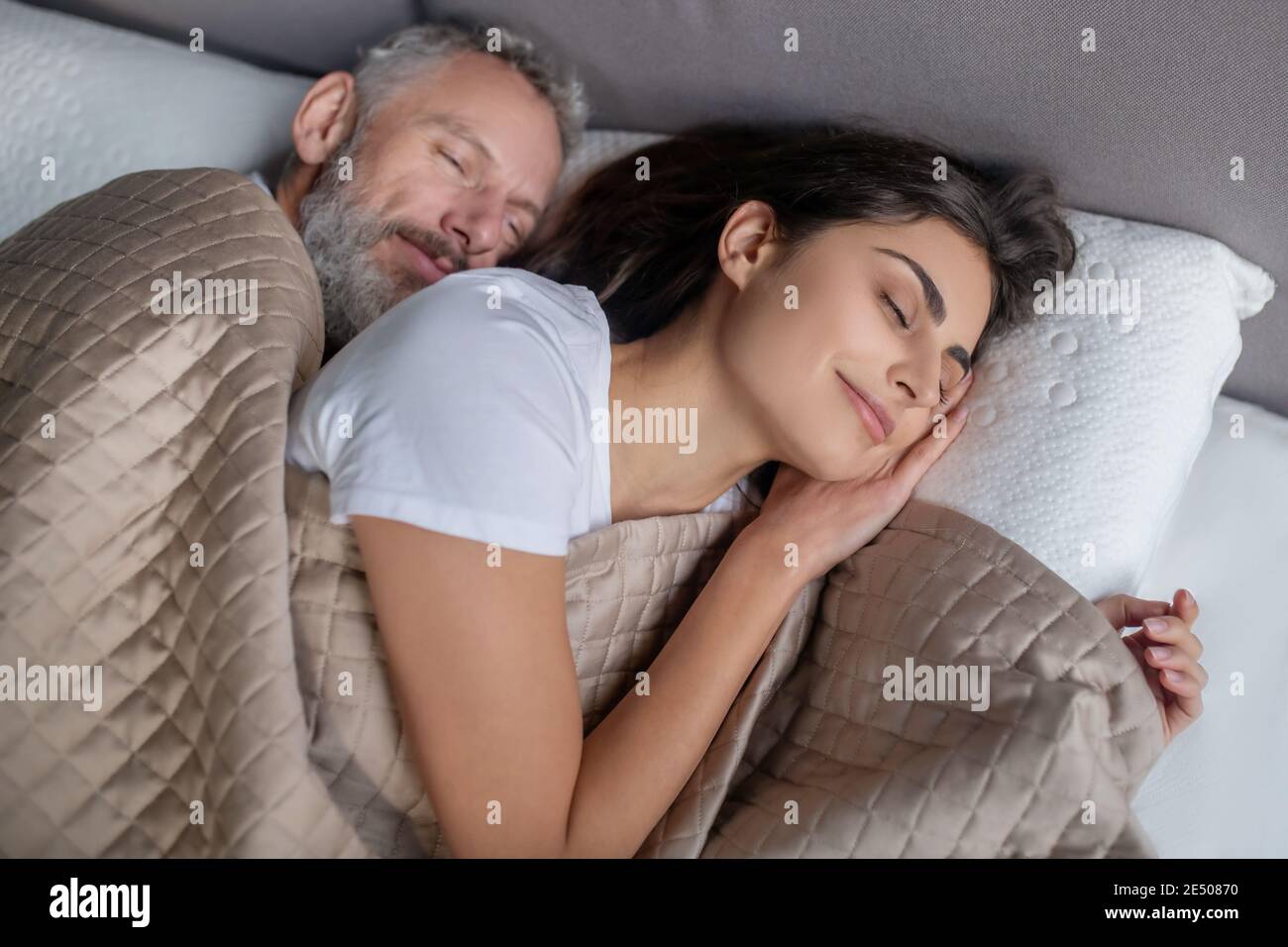 Man and woman sleeping in the bed together Stock Photo