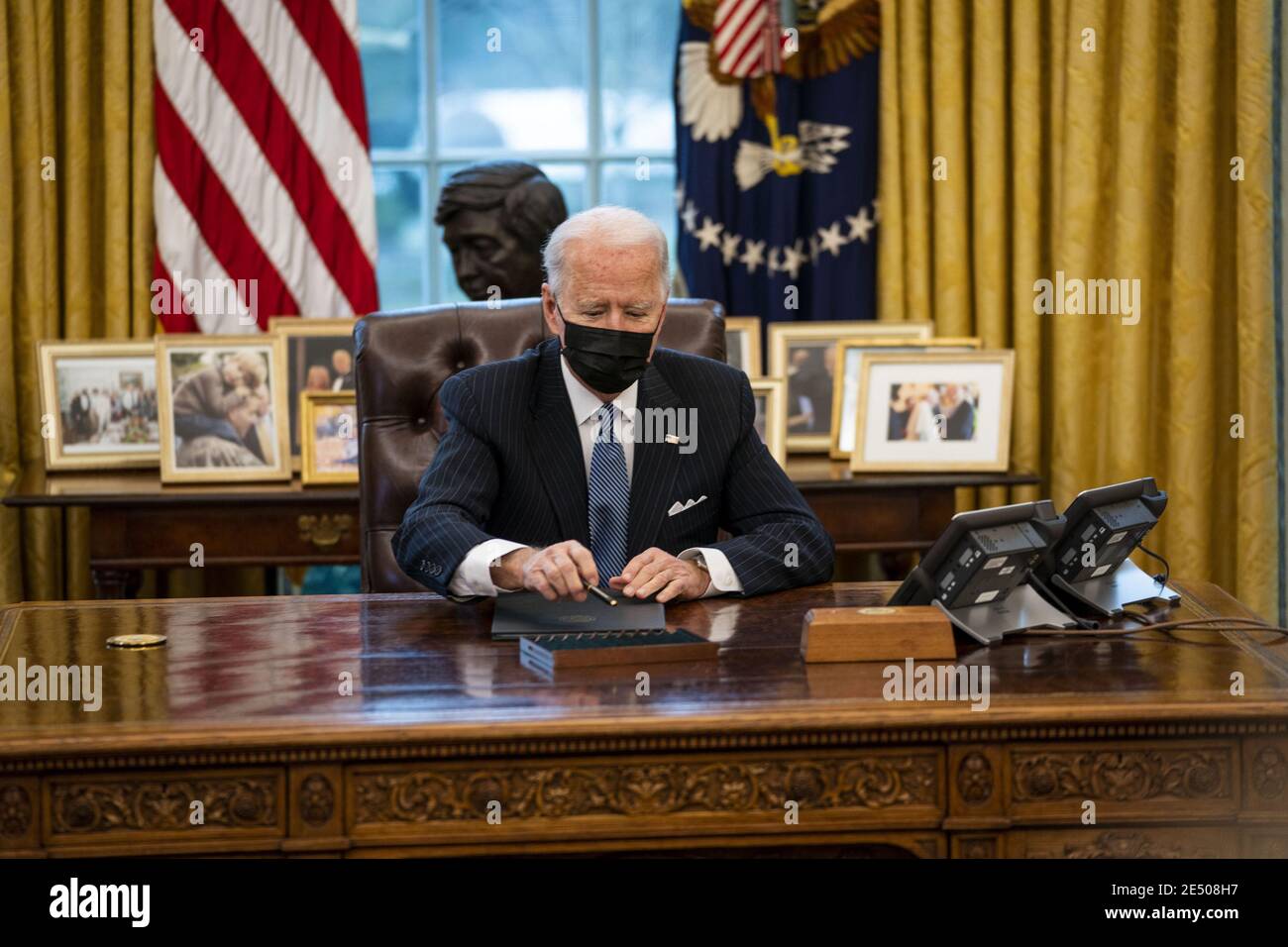 Washington, United States. 25th Jan, 2021. President Joe Biden signs an executive order reversing a Trump era ban on transgender serving in the military, in the Oval Office at the White House, Monday, January 25, 2021in Washington, DC. Pool Photo by Doug Mills/UPI Credit: UPI/Alamy Live News Stock Photo