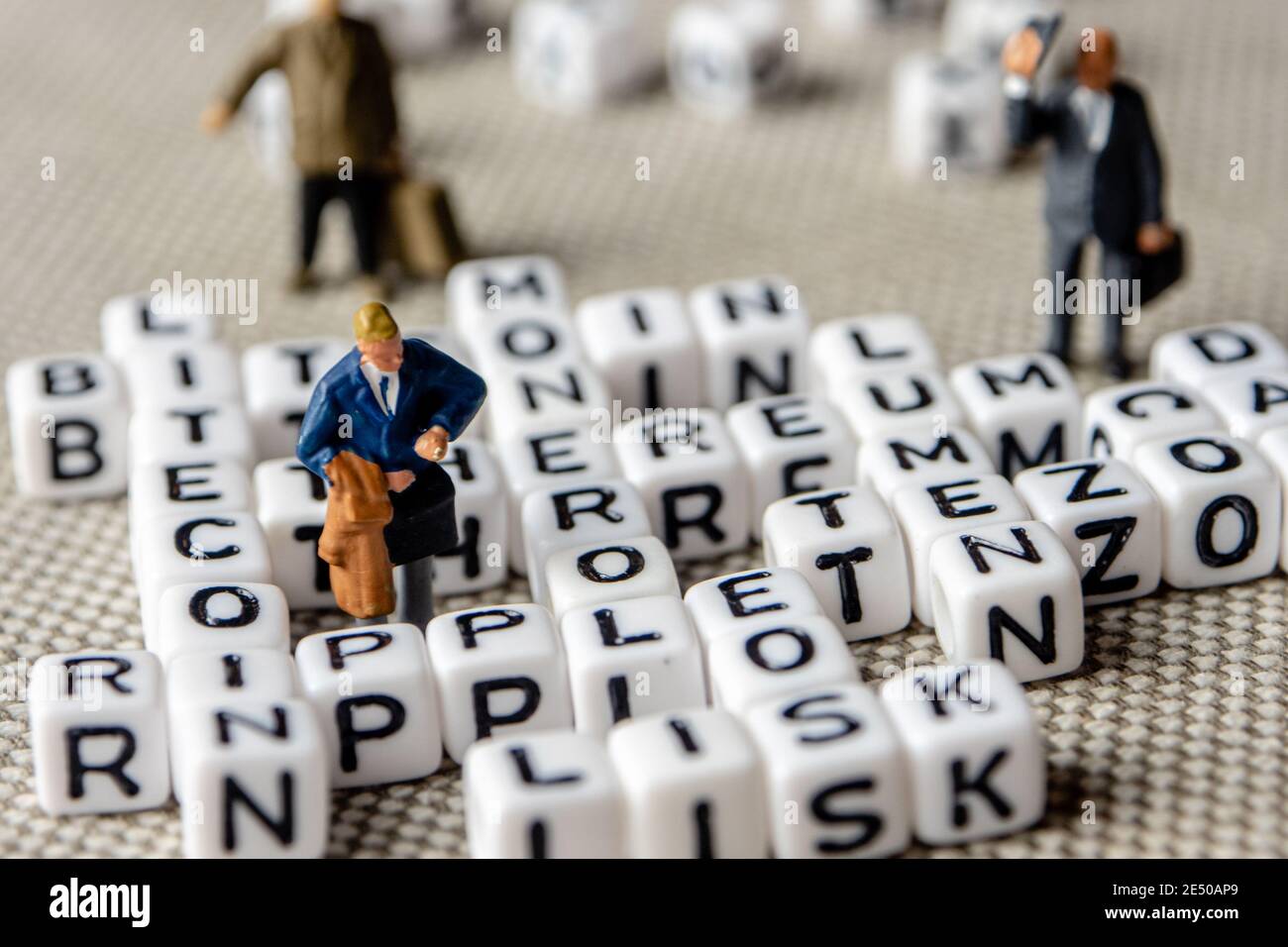 set of popular crypto coins words forming thematical crossword made of  white cubes with black capital letters and miniature businessmen figurines  havi Stock Photo - Alamy