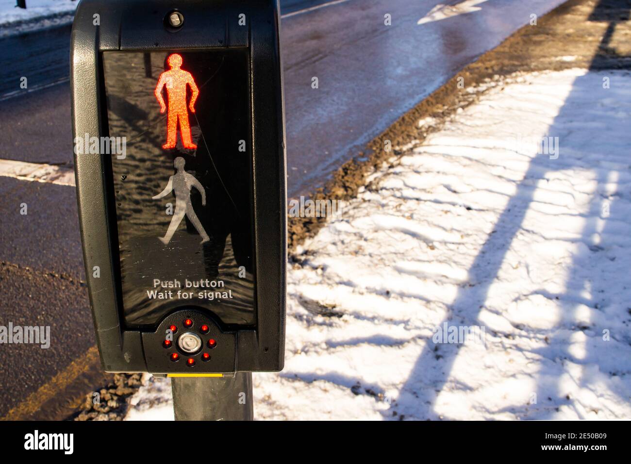 Pedestrian crossing push button, UK, red man showing, in snowy weather Stock Photo