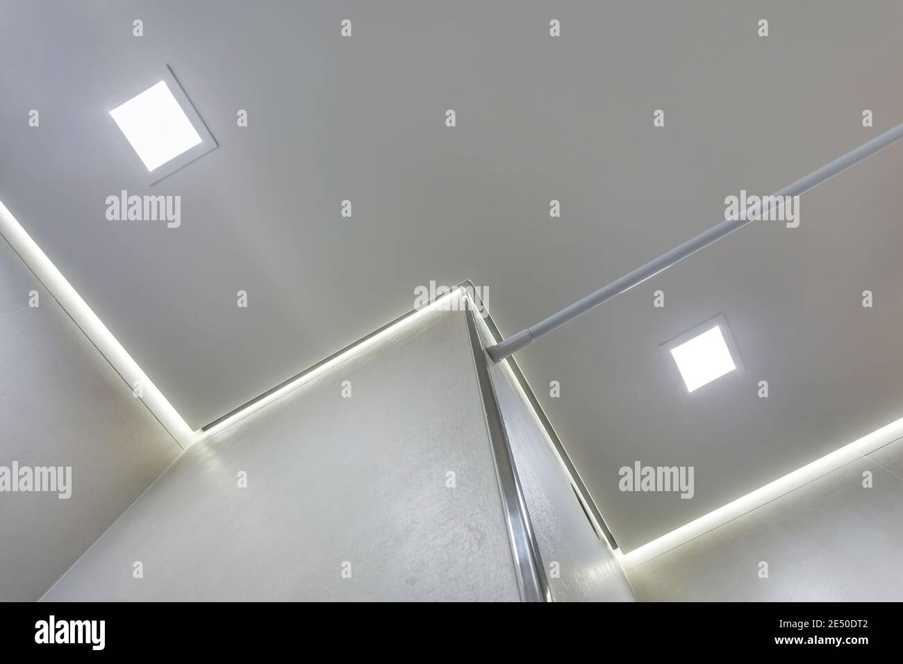 suspended ceiling with halogen spots lamps and drywall construction in empty room in apartment or house. Stretch ceiling white and complex shape. Stock Photo