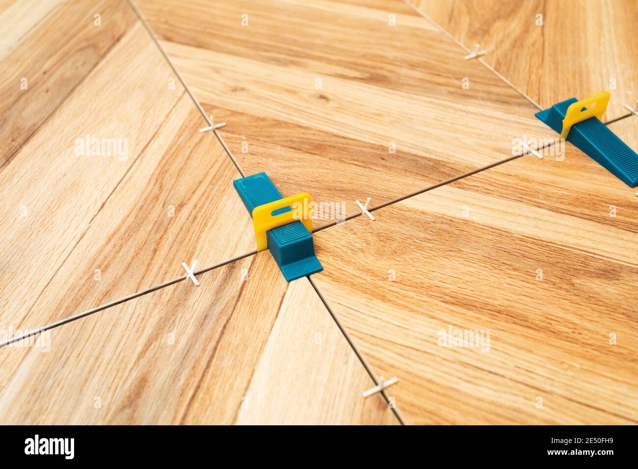 Tiling work. Layed tiles with crosses for tiles and 3d crosses Stock