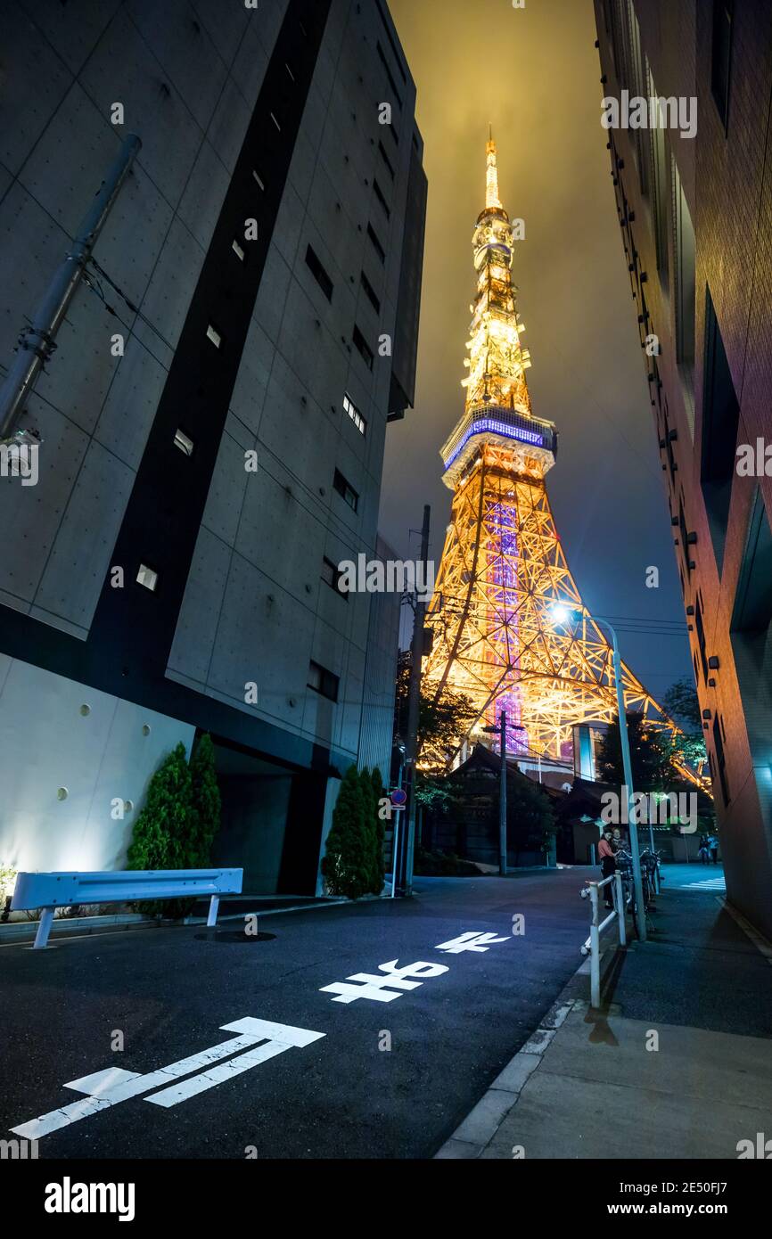 Wide angle night view of a street leading to the Tokyo Tower lit with orange light Stock Photo
