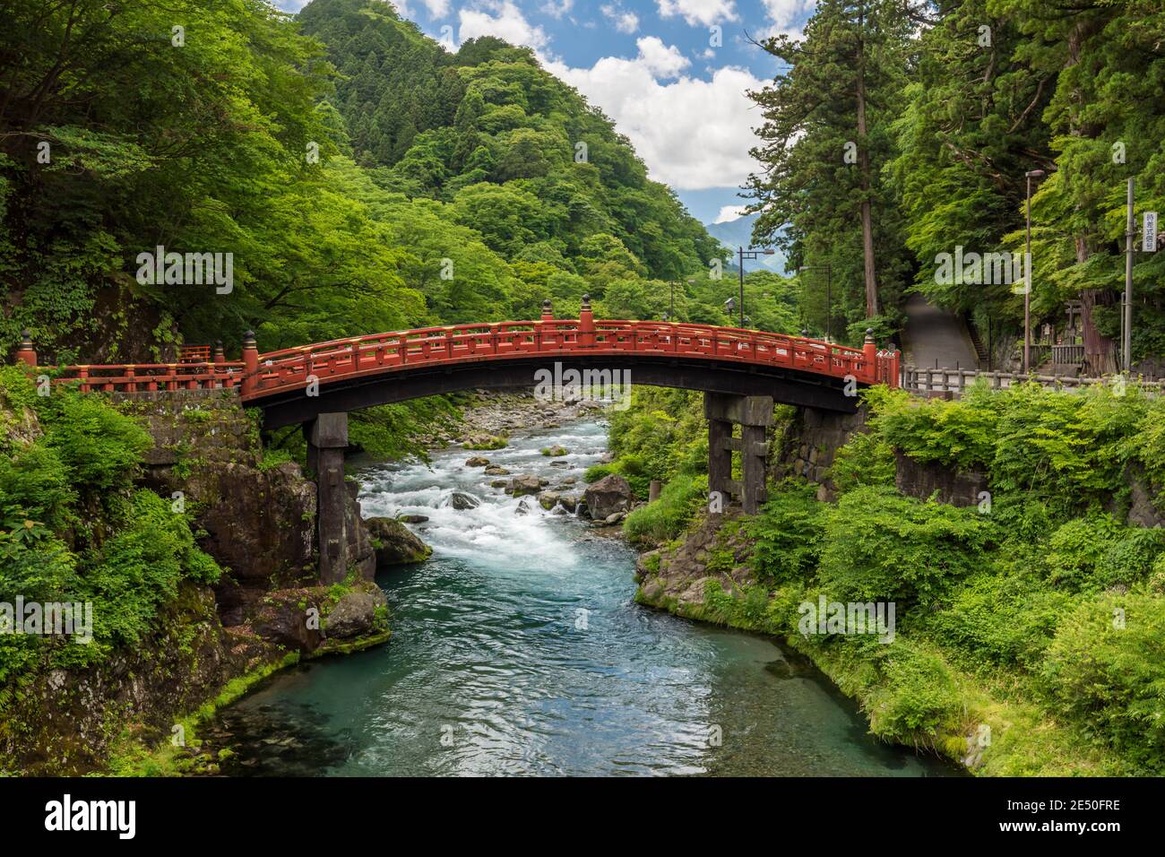 Wide angle view of a japanese landscape with green sloping hills, a red ...
