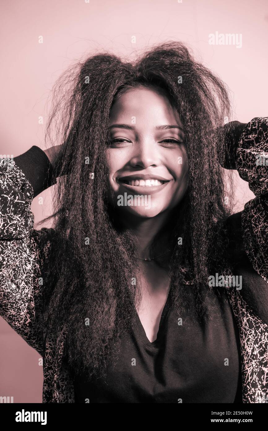 Closeup portrait of a feminine Hispanic woman smiling happily and posing in a studio Stock Photo