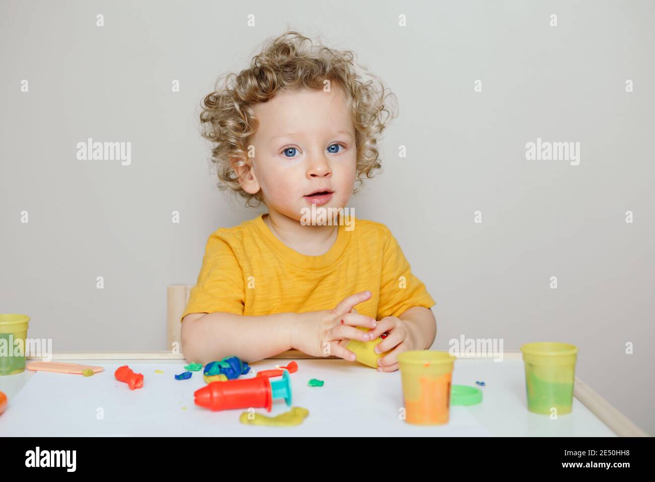 Cute Caucasian blond curly baby boy child playing with sensor