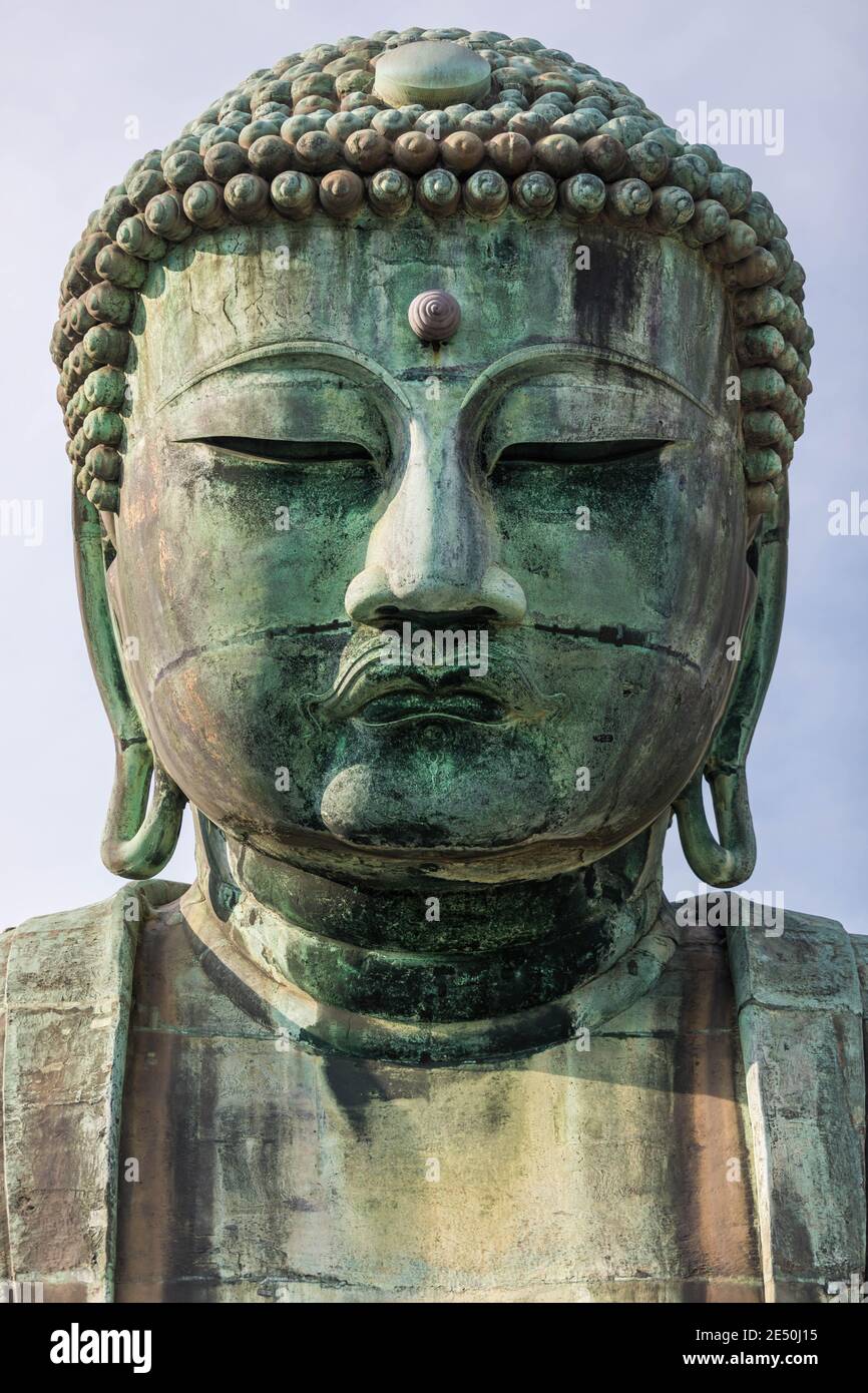 Symmetrical close up of the head of a giant bronze buddha statue Stock