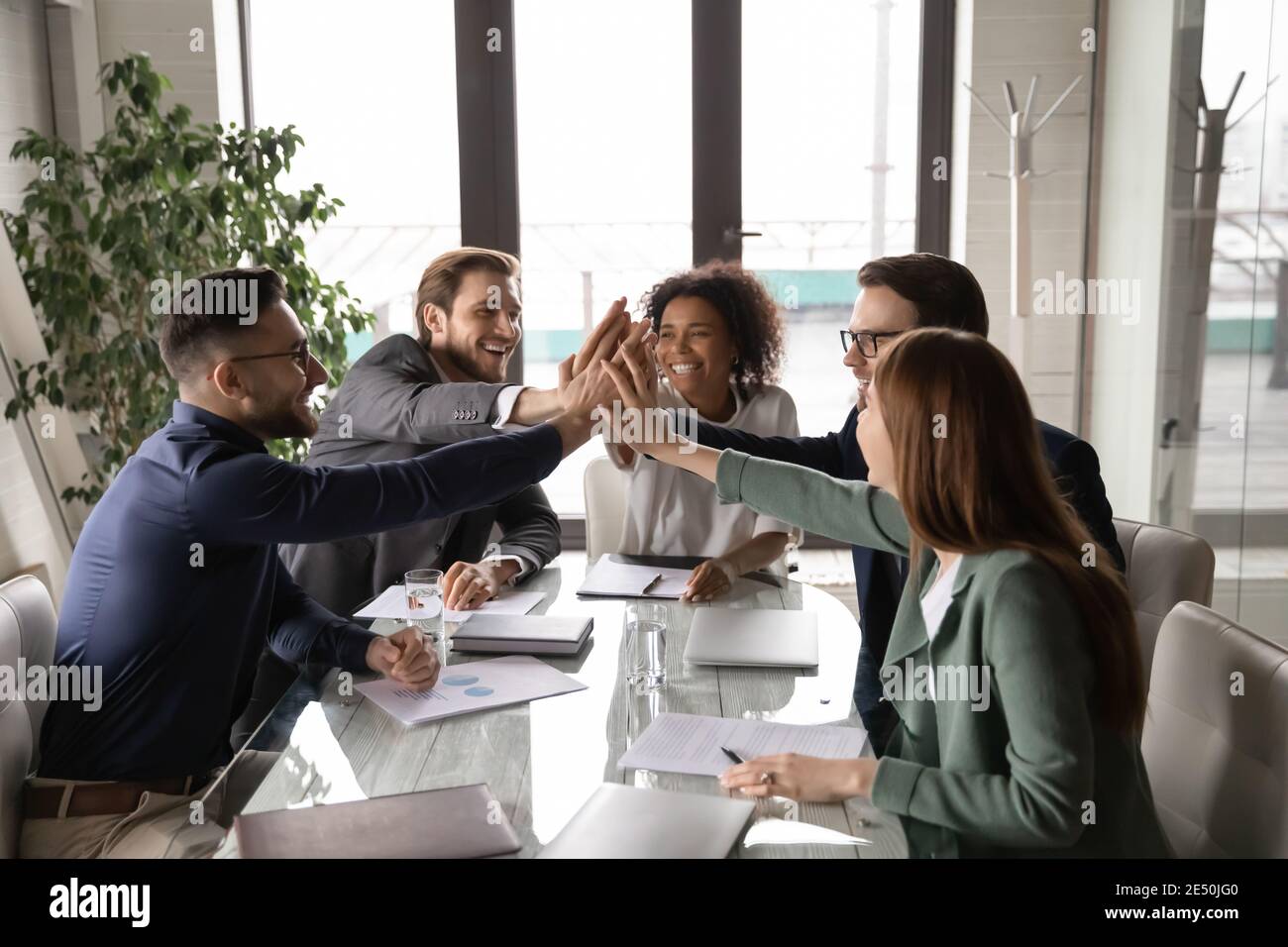 Excited diverse business team giving high five at briefing Stock Photo ...