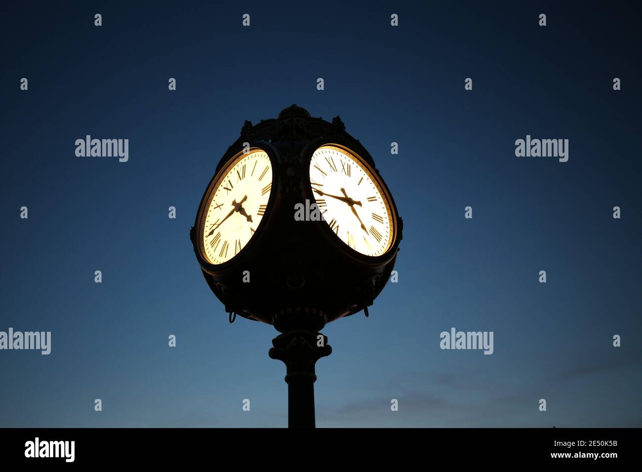 Ornate clock outside the golf course clubhouse with the Turnberry hotel in the background as dusk arrives, clock illuminated  Turnberry, Ayrshire, Scotland. UK Stock Photo