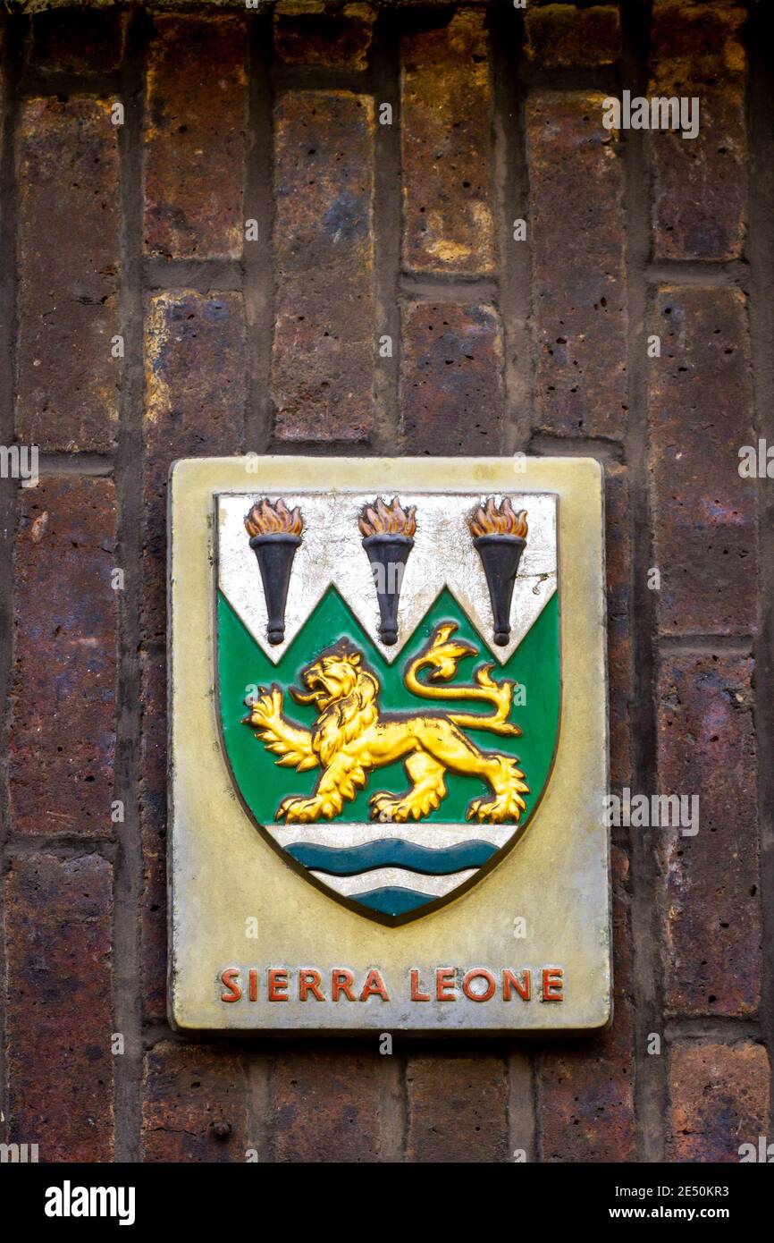 Coat of arms of SIerra Leone featuring a golden lion with outstreched tongue above blue waves Stock Photo