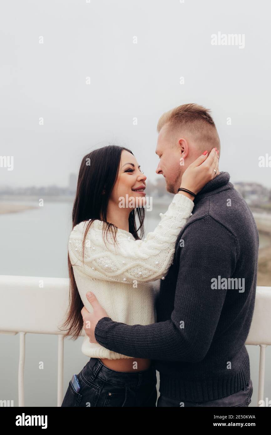 Young woman gently hugs her man against the background of a foggy river landscape. High quality photo Stock Photo