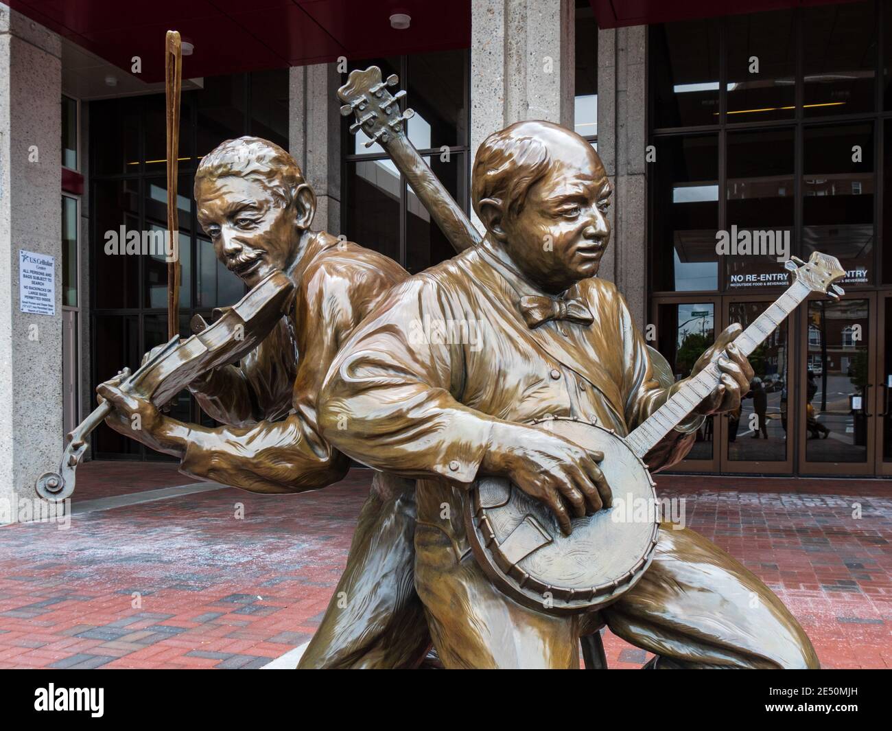 Asheville, NC - May 4, 2017: Sculptures by Gary Aslum of a banjoist and fiddler stand outside the Thomas Wolfe Auditorium and pay tribute to the cultu Stock Photo