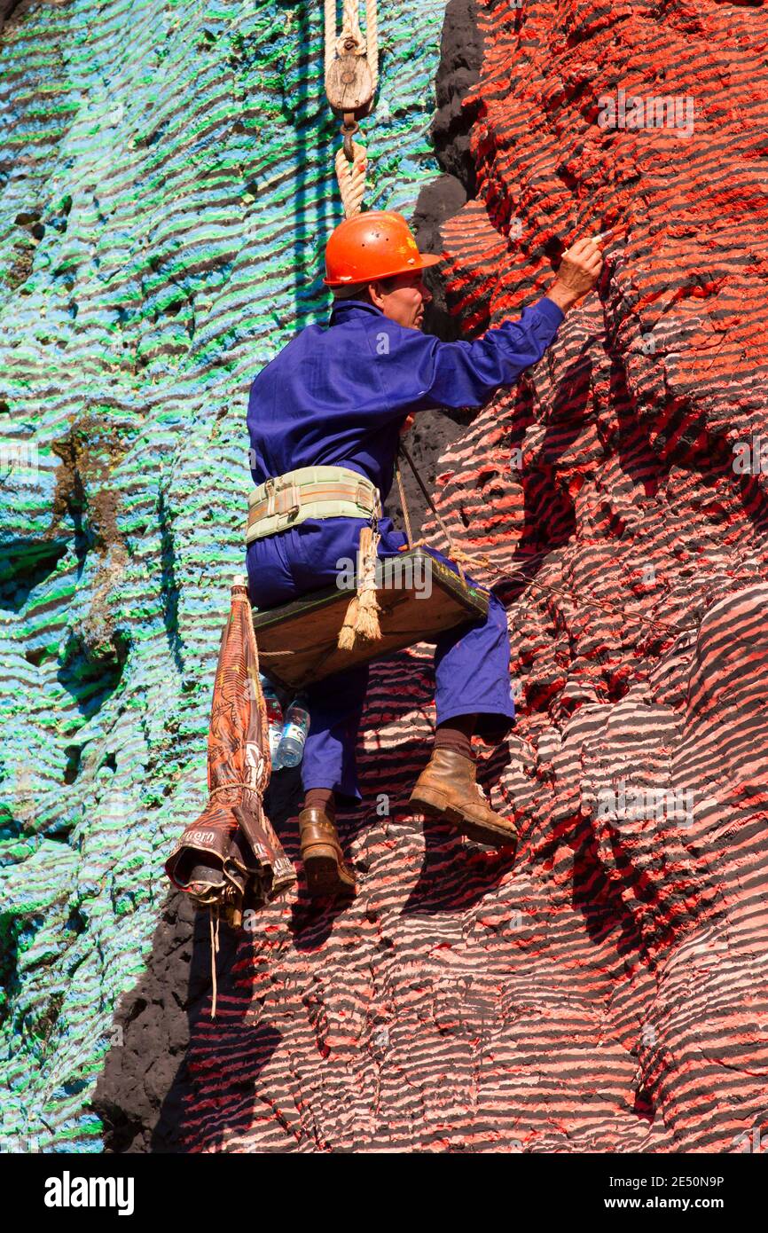 Prehistoric Rope Workman hanging from ropes, restoring paintwork of Mural de la ...