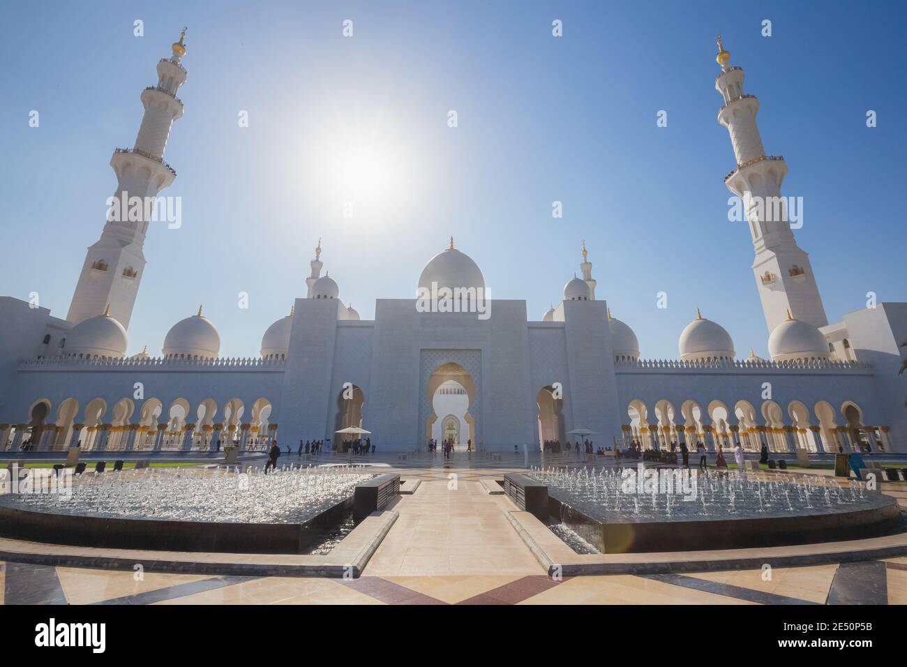 Abu Dhabi, UAE - October 7 2017: A wide angle exterior view of Sheikh Zayed Grand Mosque behind a water fountain feature on a clear sunny day in Abu D Stock Photo