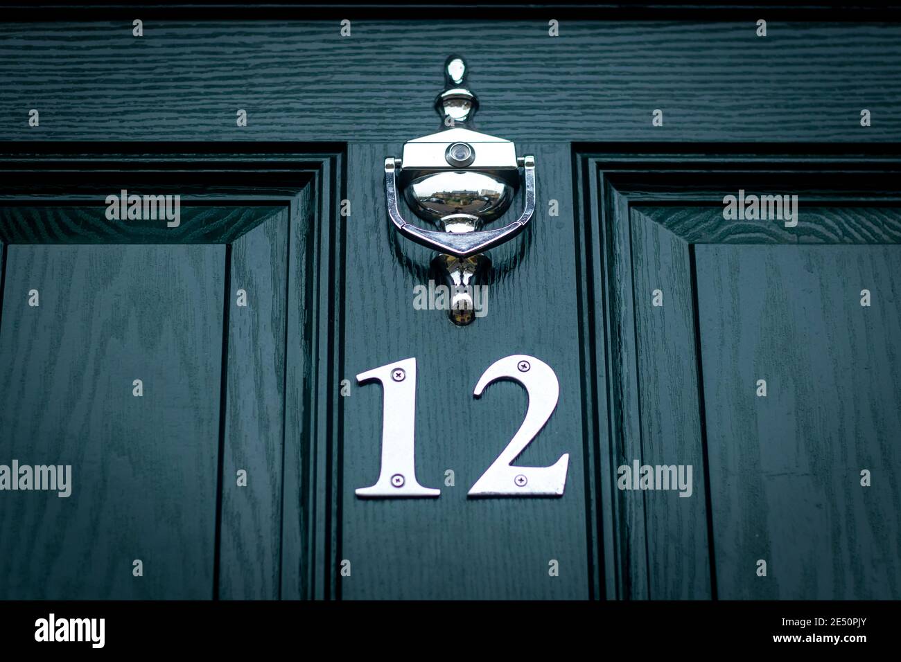 Twelve in silver metal digits on  dark green wooden front door in London, England Stock Photo