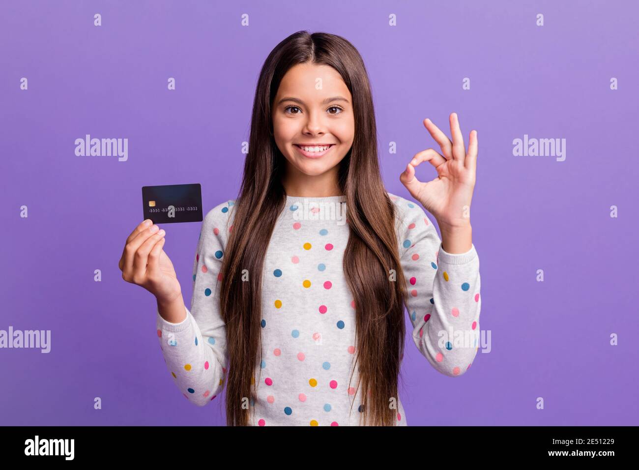 Photo portrait of cheerful small girl showing bank card showing okay ...