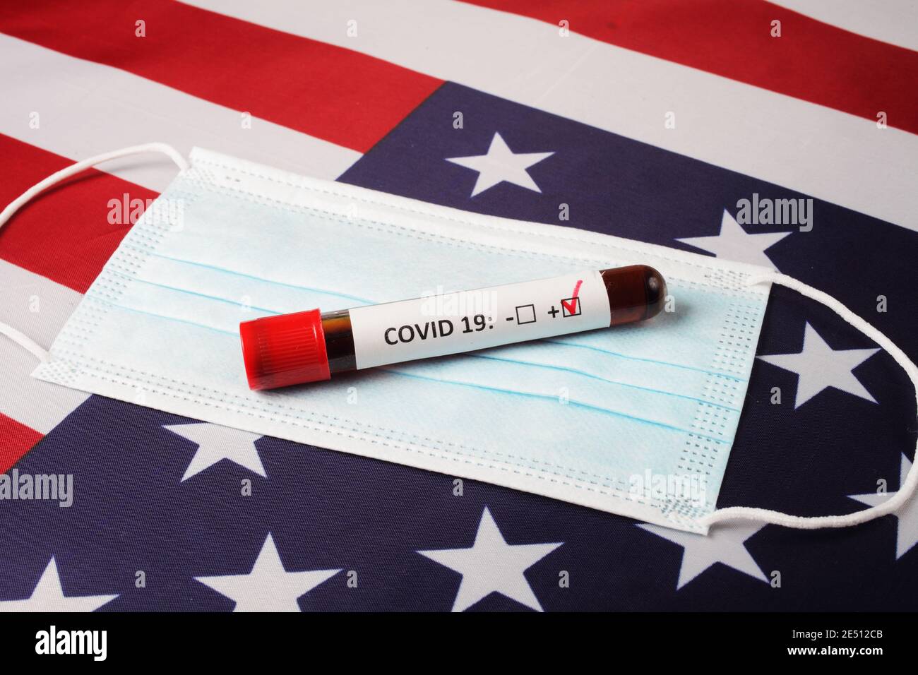 Medical mask and blood collection tube on the usa flag, close-up. Stock Photo