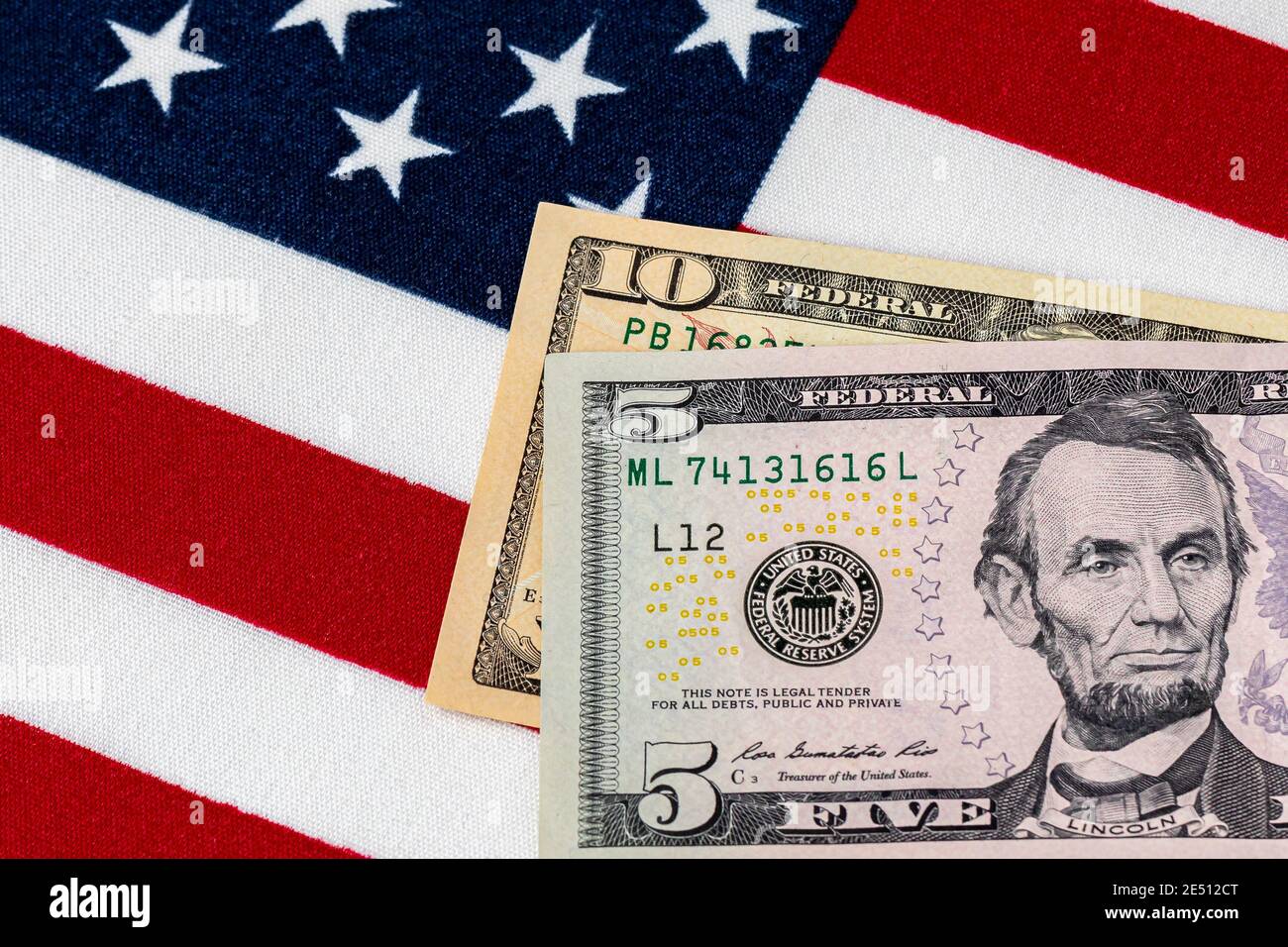 Closeup of ten and five dollar bills with American flag.  Concept of 15 dollar federal minimum wage increase. Stock Photo