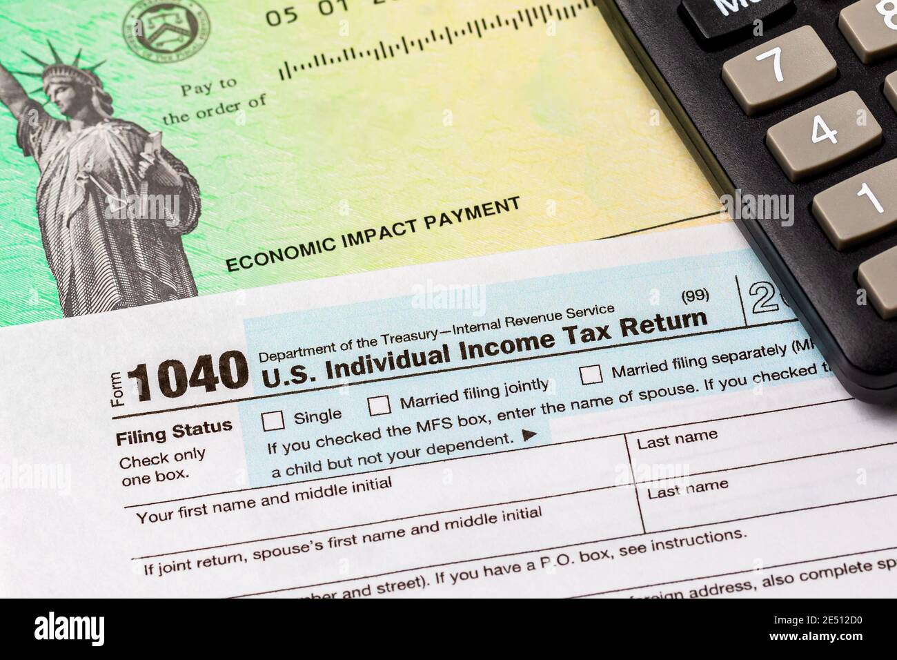 1040 individual income tax return form and economic impact payment or stimulus check. Concept of filing taxes, taxable income and tax information. Stock Photo