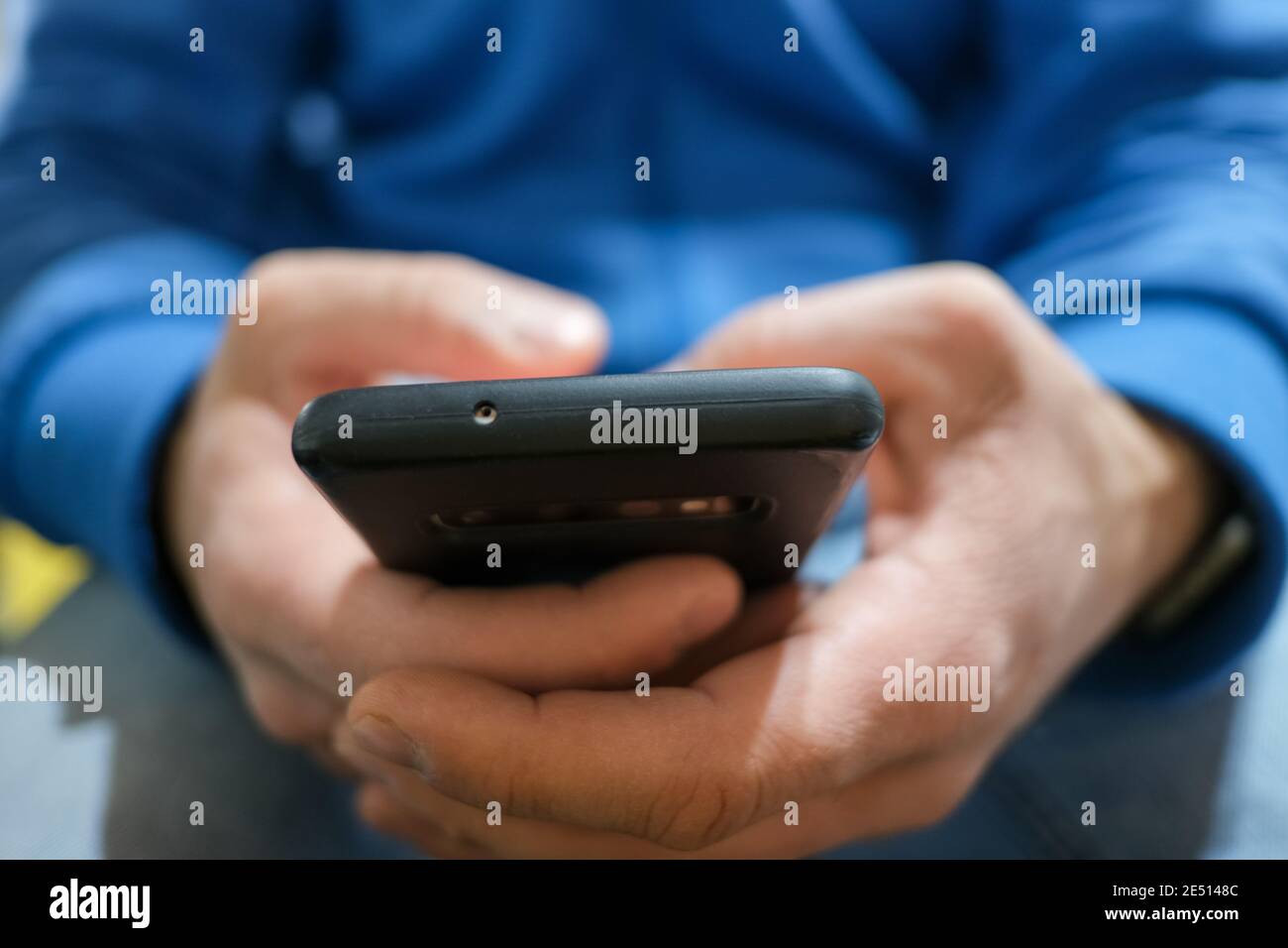 Close up view of a Guy while using smartphone,cellphone tech addiction  Stock Photo